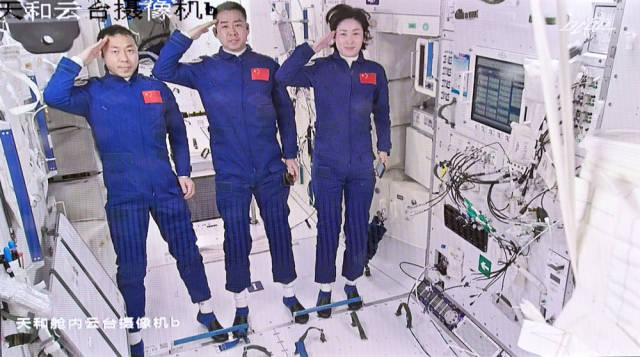 2022年6月5日在北京航天飞行控制中心拍摄的进驻天和核心舱的航天员陈冬（中）、刘洋（右）、蔡旭哲向全国人民敬礼的画面。新华社记者 李鑫 摄