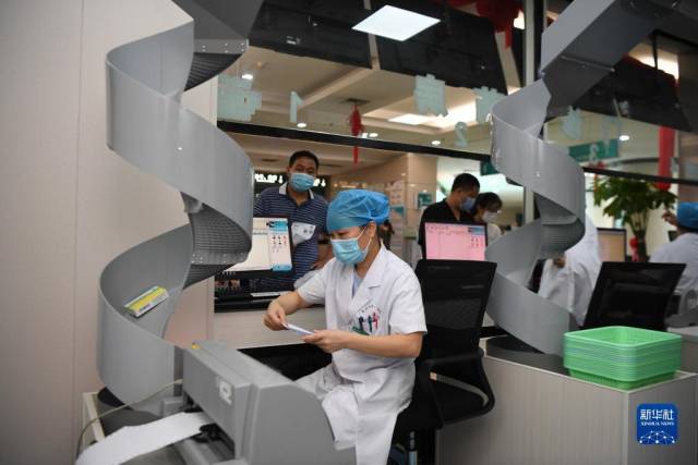 2021年8月11日，医务人员在湖南省长沙市第一医院门诊智慧药房为患者发放药物。新华社记者 薛宇舸 摄