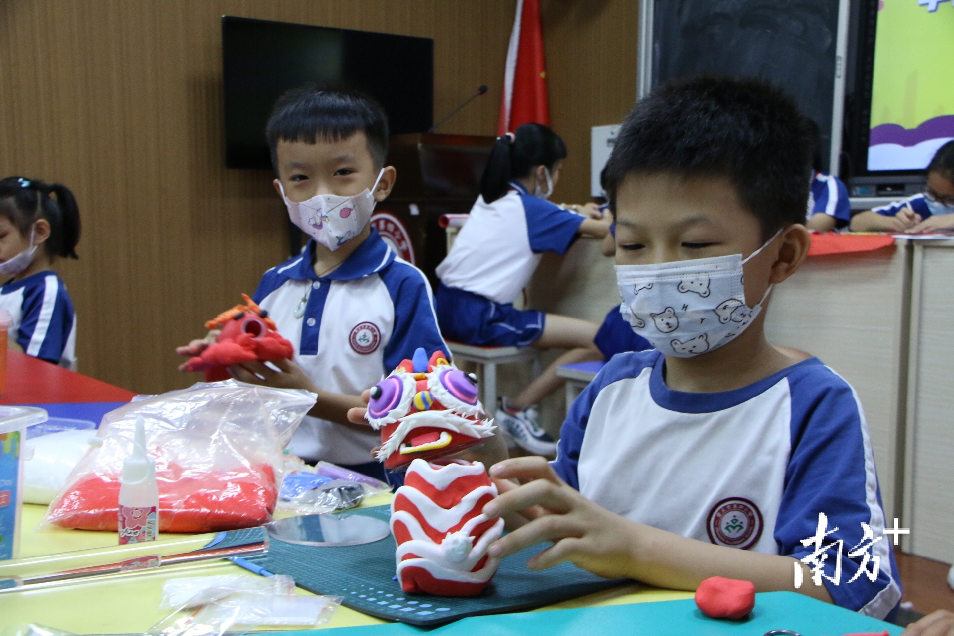 学生制作狮头黏土造型作品。 南方+ 卢舒曼 拍摄