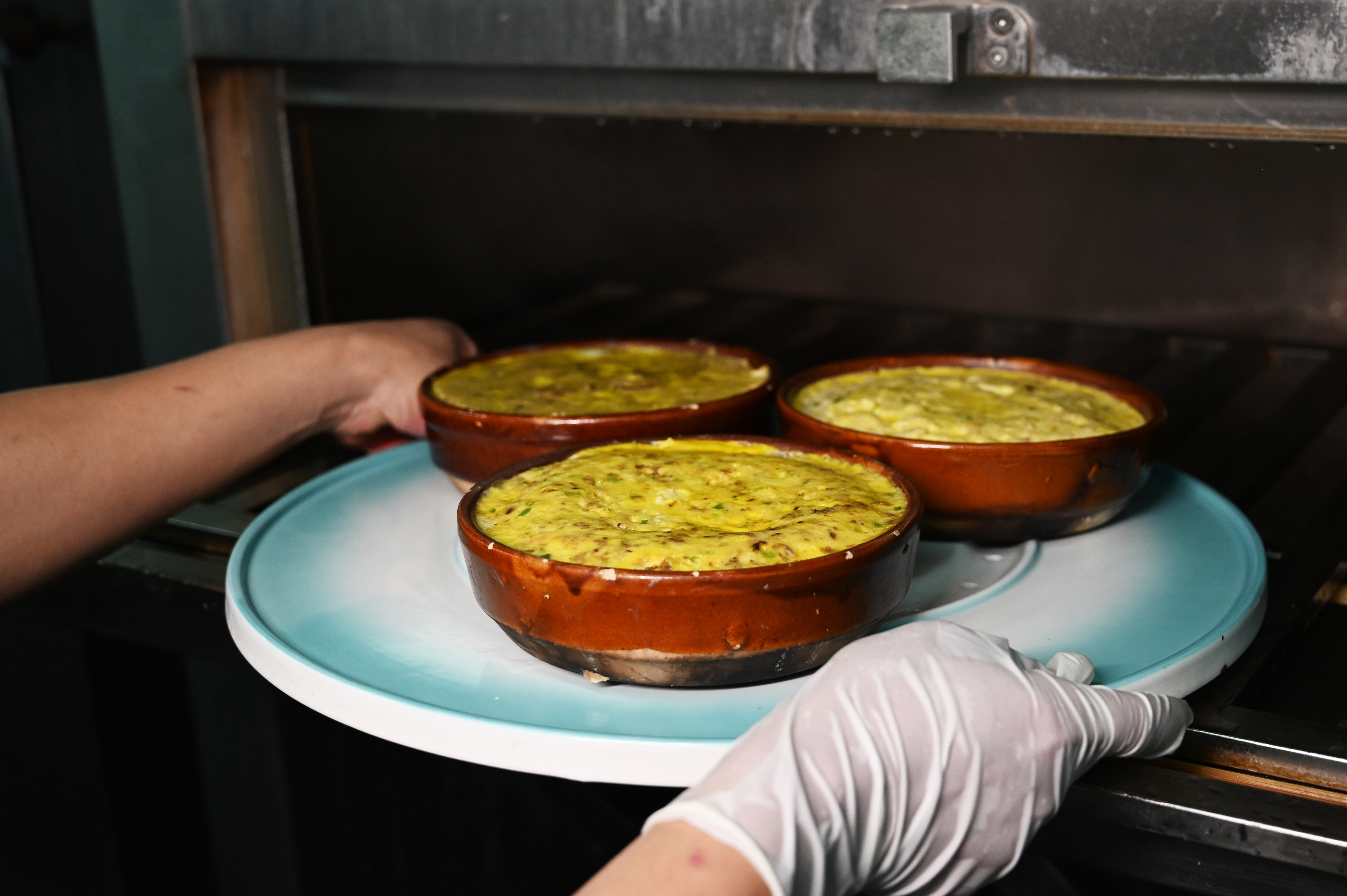 制作流程之一：将新鲜禾虫、花生油、蒜蓉、陈皮丝放置砵仔当中搅拌，蒸40分钟熟透。