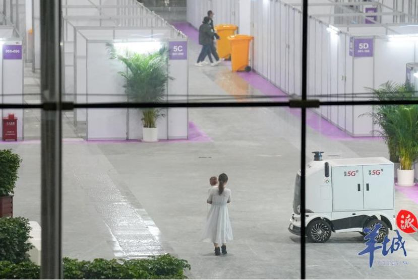 琶洲方舱医院内部已有人员活动，部分人员身穿防护服，另一部分穿着日常服饰。