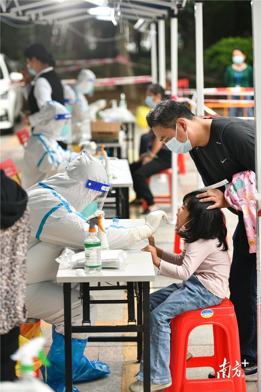 8日傍晚，赢之城南门广场，一名小女孩在家长的帮助下进行核酸检测。曾亮超 摄