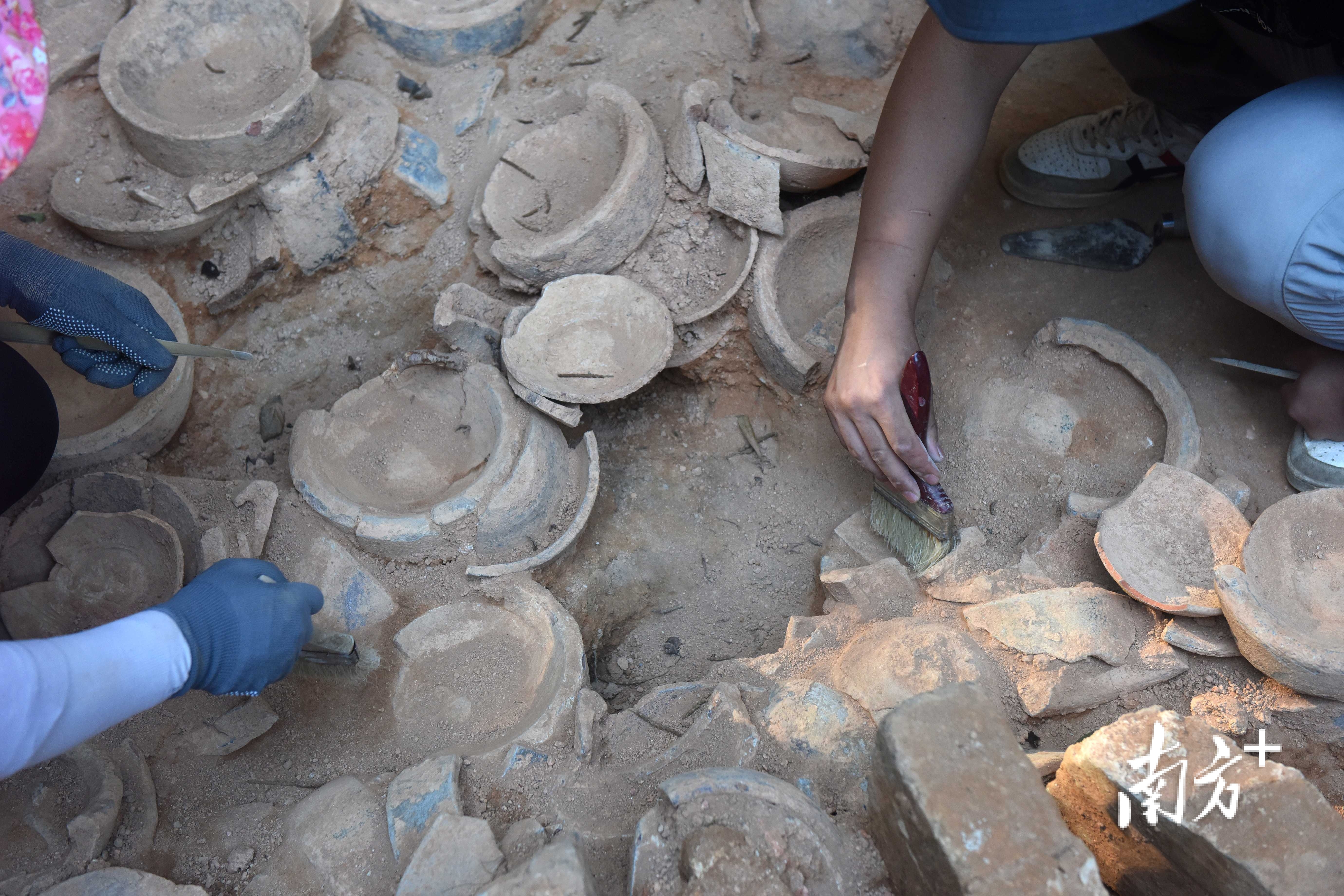 工作人员小心翼翼地清理出土坑里的瓷器。