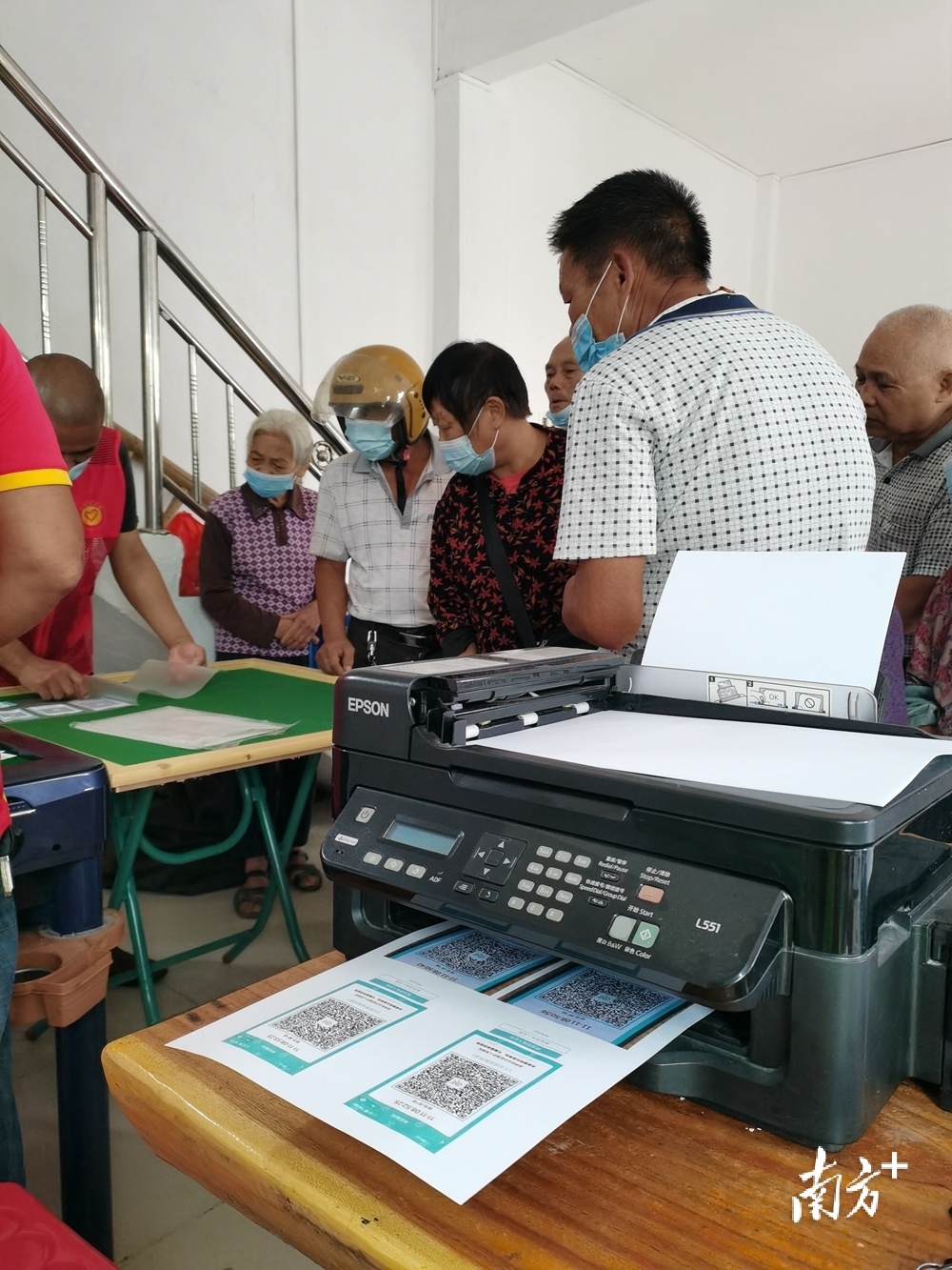 听到台前村委有老人被二维码问题困扰多日，东鹏陶瓷志愿者自带彩色打印机、过胶机等设备现场为老人家小孩打印二维码。