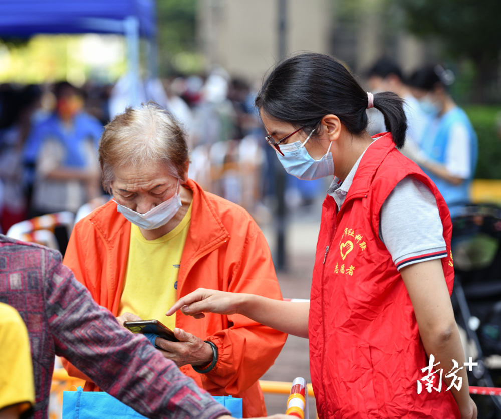 志愿者在清城区万科华府核酸检测采样点服务。曾亮超 摄