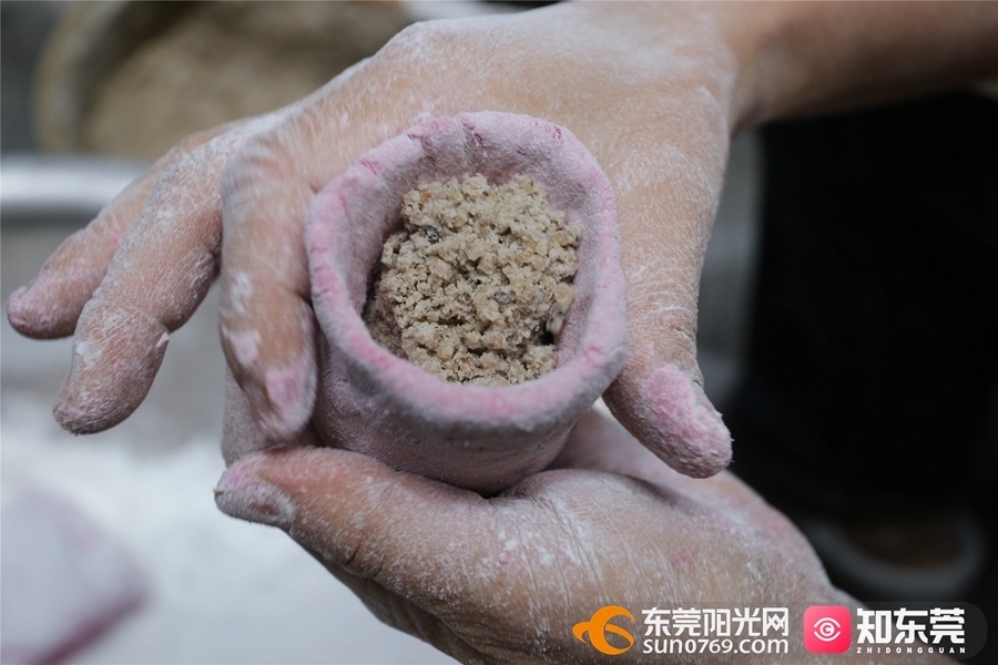 ▲一边往皮里塞馅料,一边将其封口。 ▲一边往皮里塞馅料,一边将其封口。