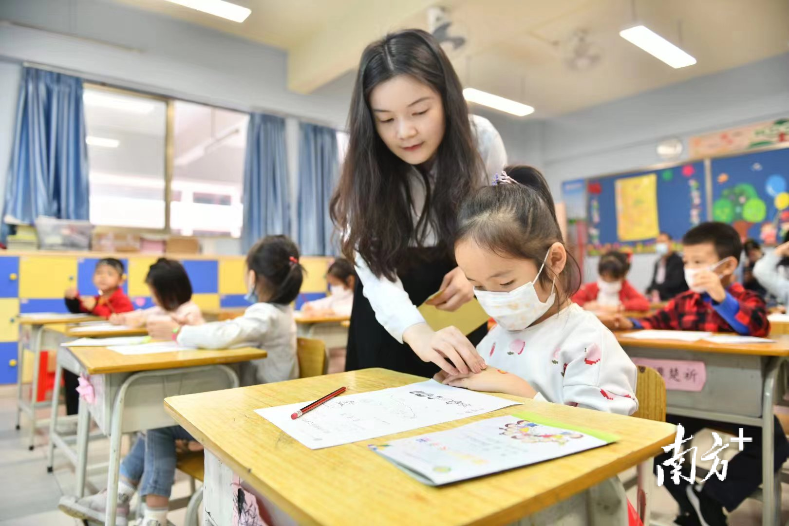 打造高质量的教师队伍是佛山基础教育迈向新阶段的重要基石。图为高明区沧江中学附属小学，老师为学生贴上奖励的贴纸。戴嘉信 摄