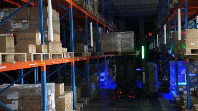 纬创资通中山厂的“关灯库房”内，无人叉车正在自动运送货物。