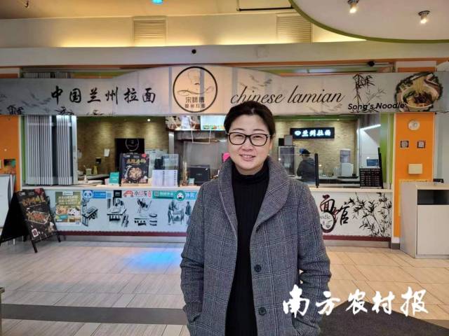 尹俐骄在自己经营的拉面馆前。