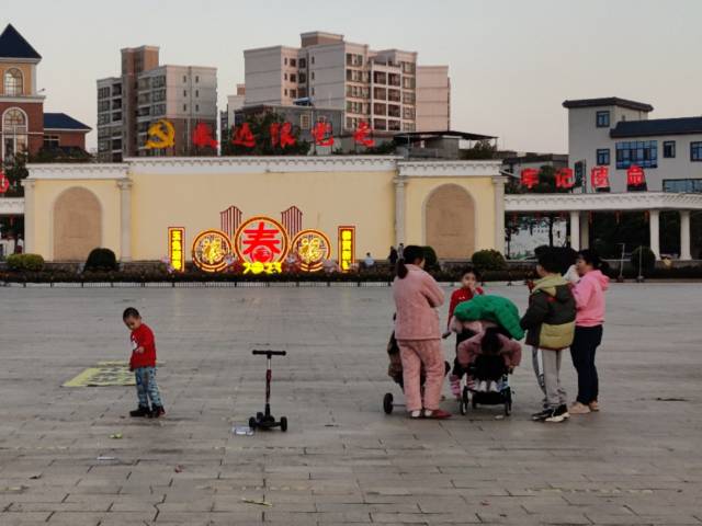 石坝镇广场上散步的大人小孩