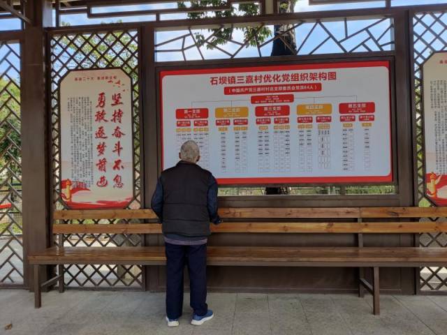 91岁的周赐英老人经常到龙底广场的党建长廊散步