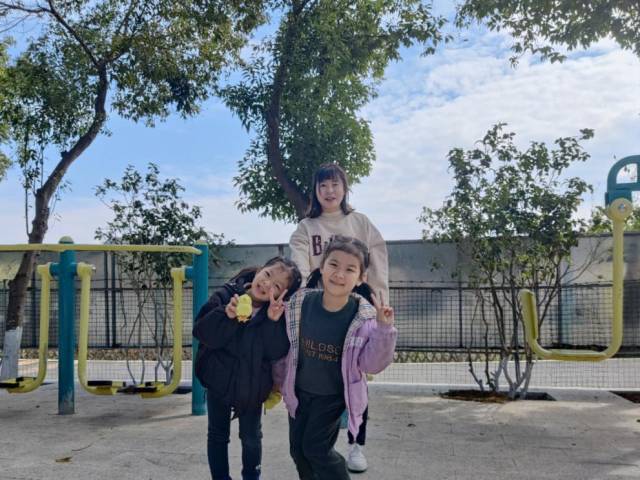 三嘉村龙底广场，张女士带着女儿和侄女一起玩耍