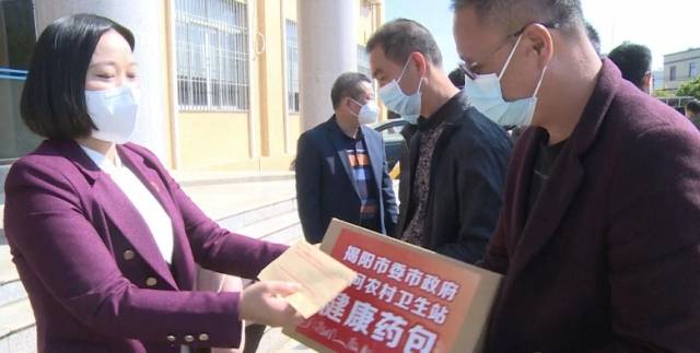 惠来县卫生健康局党组书记、局长方少珠（左一）等向各村卫生站负责人送上健康药包。