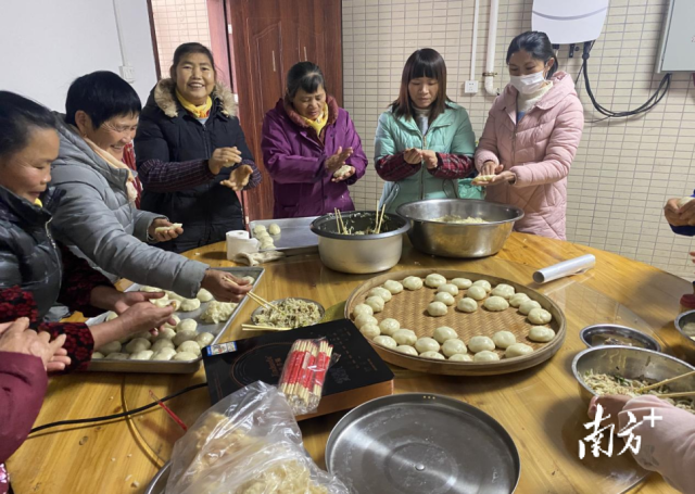 妇女们围在一起做糍粑，寓意来年生活甜蜜团圆。