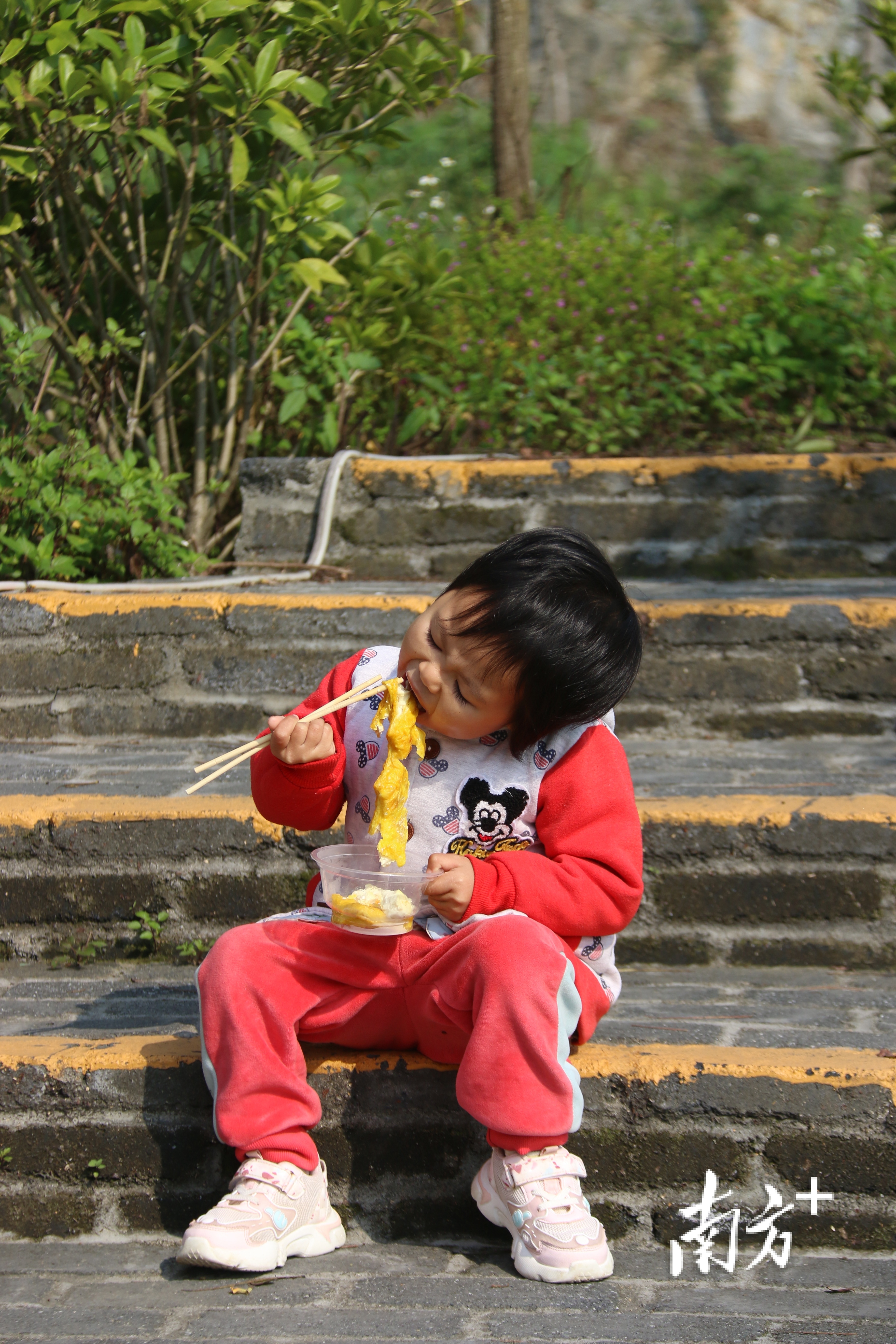 小孩坐在地上品尝九龙豆腐。陈咏怀 摄 