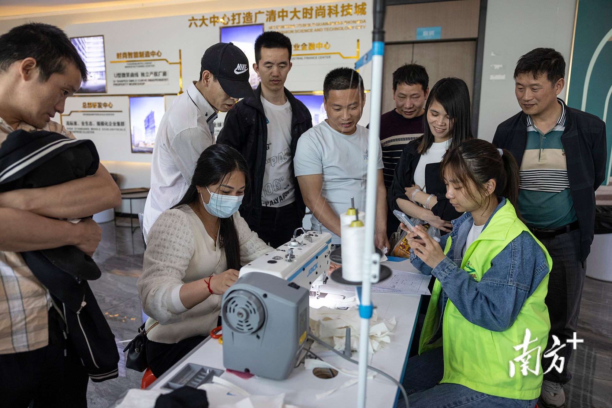 制衣工人进行平车技能测试，“广州北·中大时尚科技城”的工作人员在一旁计时。