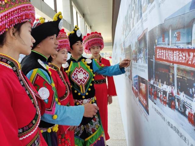 韶关市乳源瑶族自治县的瑶族青年在法治历史图展区韶关版前寻找历史印记。