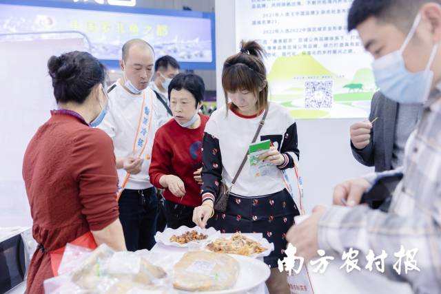 参展客商品尝韶关特色农产品。