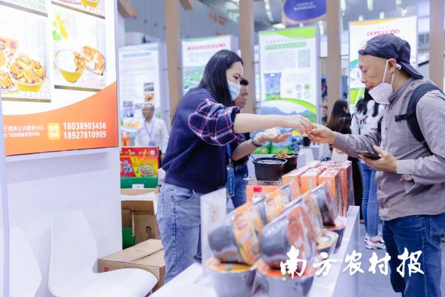 参展客商品尝韶关特色农产品。