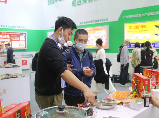 何浩華（左）向采購商介紹公司情況