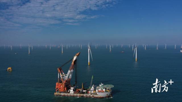 阳江沙扒风电场上，海上风机排列整齐，风机吊装船只正在作业。