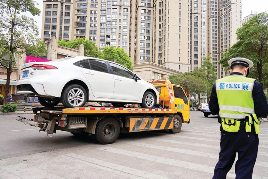 惠城区桥东街道综合行政执法队将违停车辆拖走。