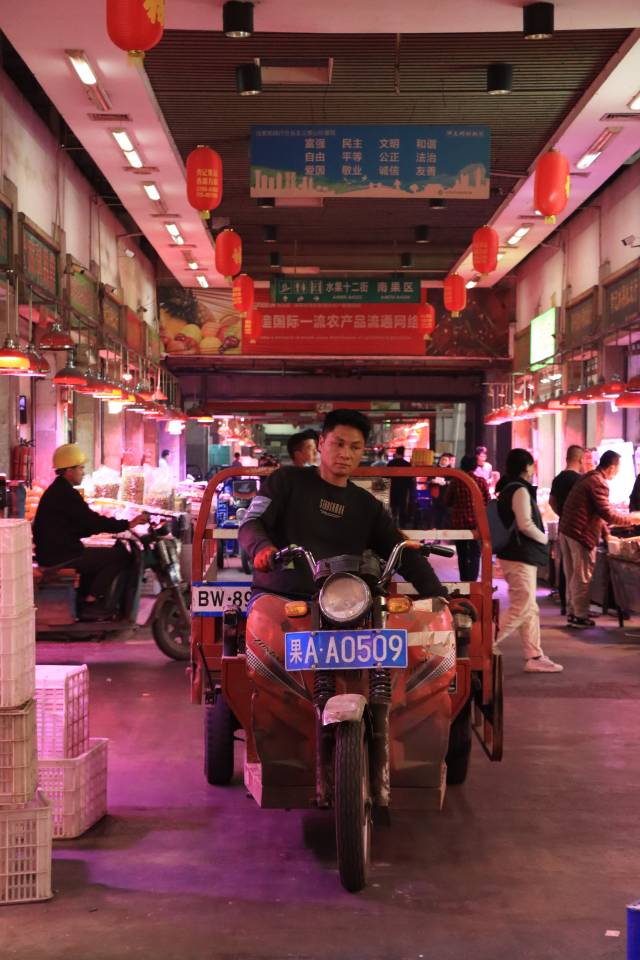 深圳海吉星水果交易區(qū),，小車在狹窄的走廊里穿梭。
