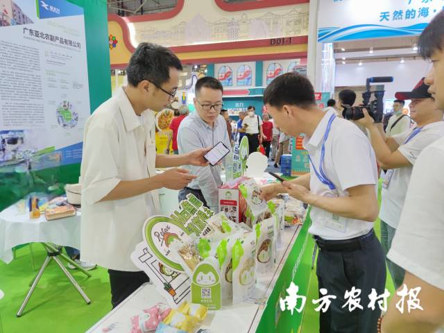 徐可武（左三）在展位前仔细了解曲江食用菌产品。 林晓岚 摄