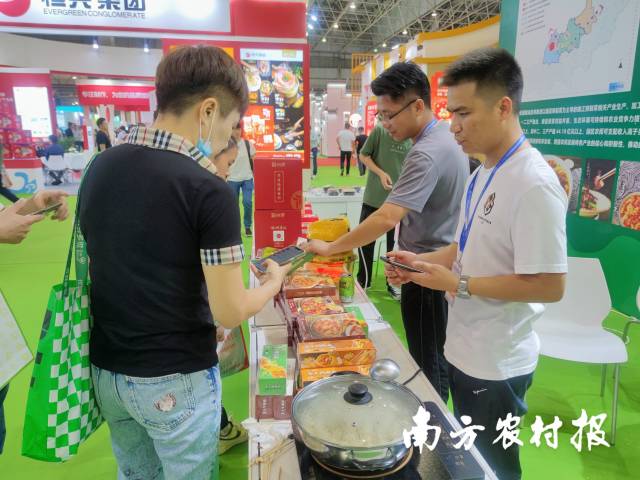 参观者在广东亚北农副产品有限公司的展位前品尝预制菜。 林晓岚 摄