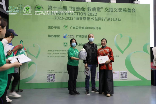 黄佩霞女士（右）将捐赠的老陈皮转交给买受人（中）。