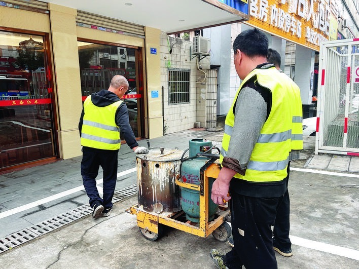 工作人员在开展停车格划线工作。 工作人员在开展停车格划线工作。