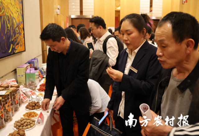 采购商在2023年广州从化荔枝推介会上品尝从化荔枝系列加工产品。