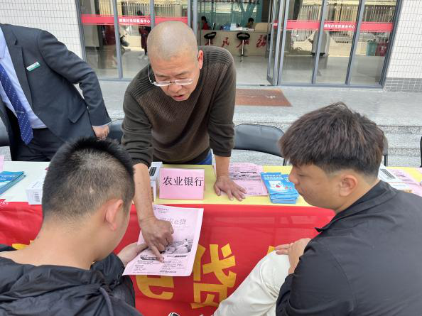 陈肯秋向农民推广金融产品。