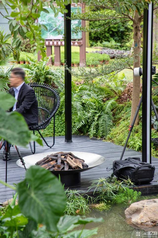莳花寻梦|由极简主义的小屋及凉棚构成。茂密的树木包围着钢结构的凉棚，棚中生长的树枝和穿越其间的水流，体现出人类与自然紧密联结的理念。