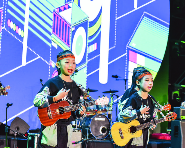 惠阳推动吉他制造业向文化、艺术、教育、工业旅游领域拓展延伸。这是孩子们在舞台上进行吉他弹奏。