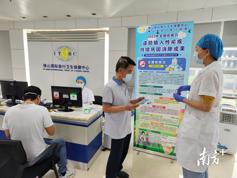 佛山海关工作人员向市民普及防疟知识。