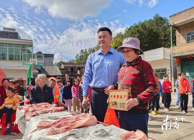 敬梓镇南村村给干净整洁户发猪肉。