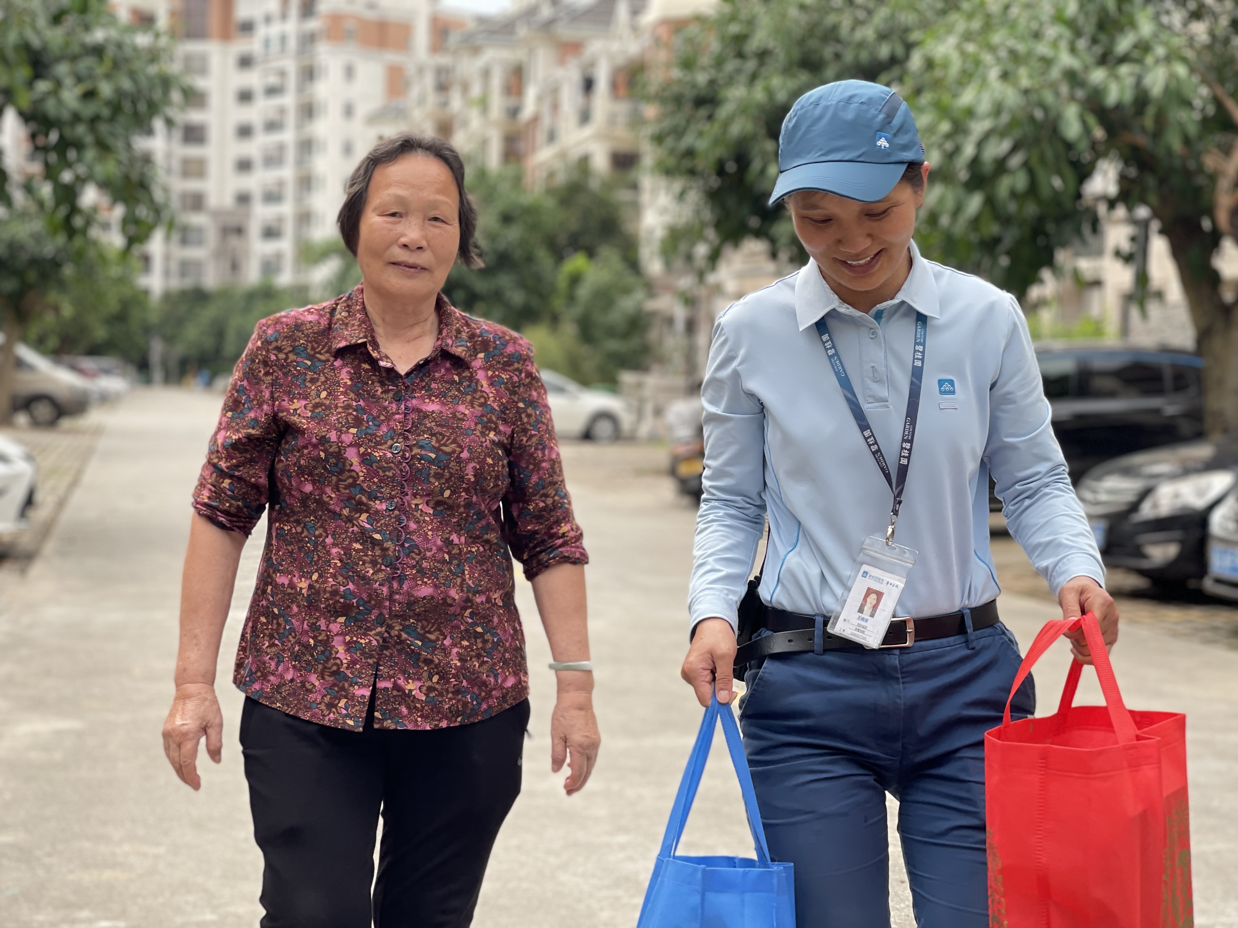 王晓丽帮年长的业主提重物。