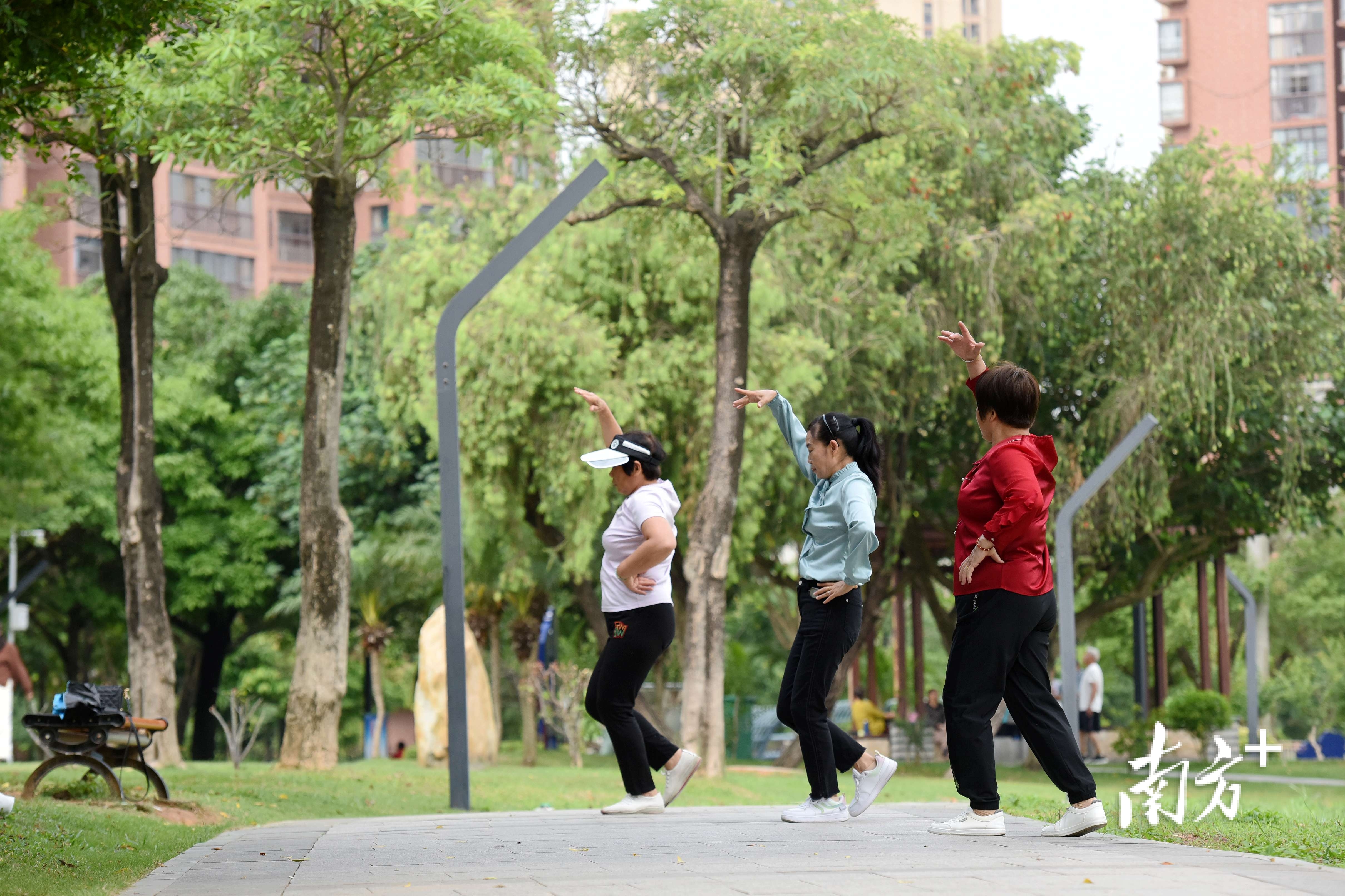 跳舞的市民享受绿美公园。 