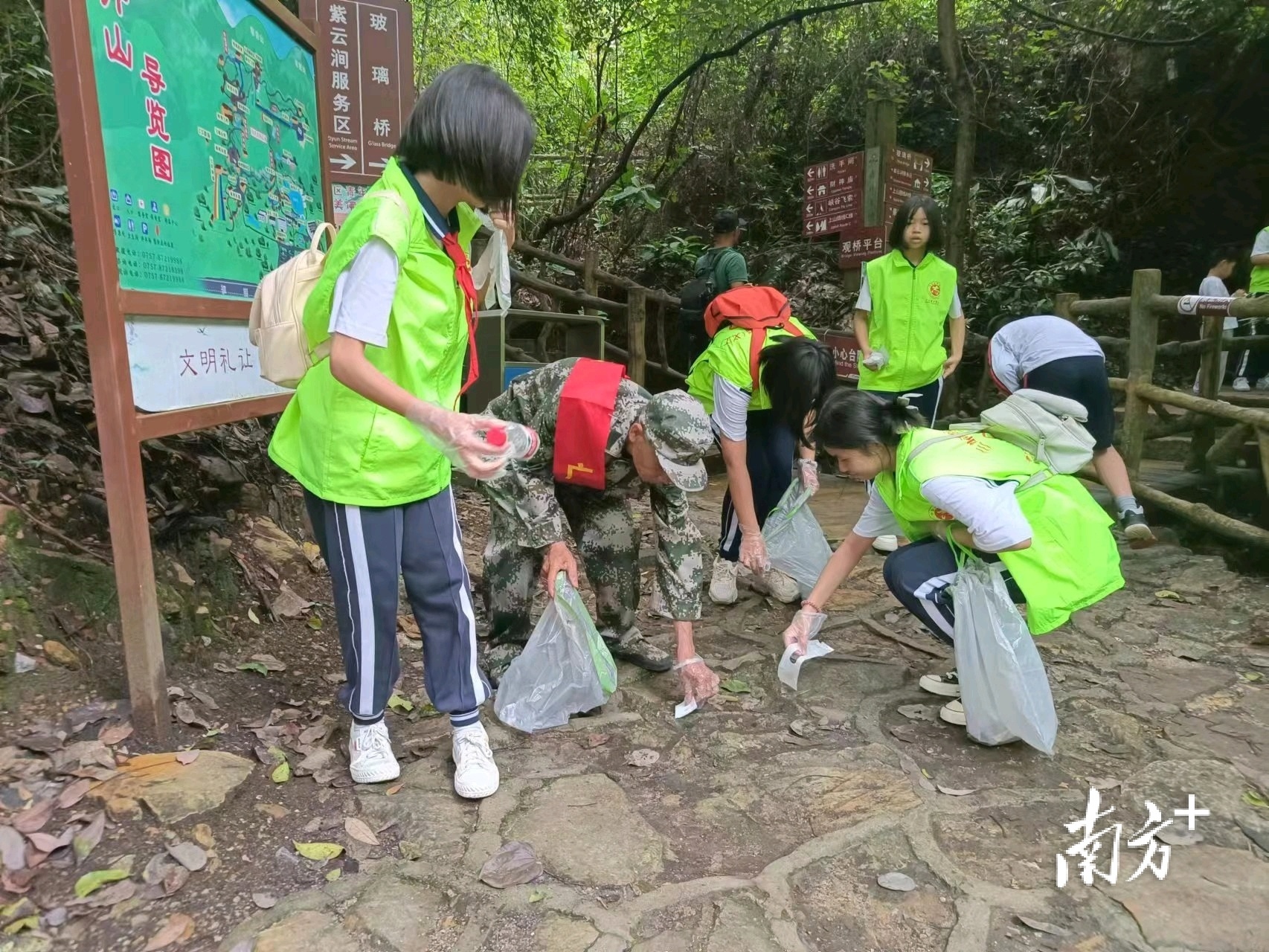 活动中,志愿者、少先队等代表边徒步边捡垃圾,用实际行动来倡议文明旅游和爱林护林。