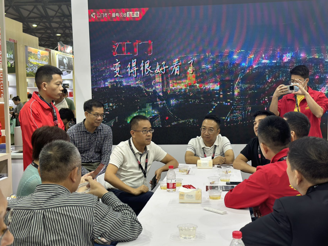 江门市副市长曹阳（左3），江门市农业农村局局长郑少强（左4）在展区与企业开展座谈交流