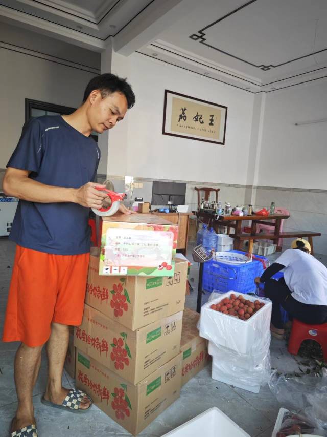 何国喜正在打包荔枝。