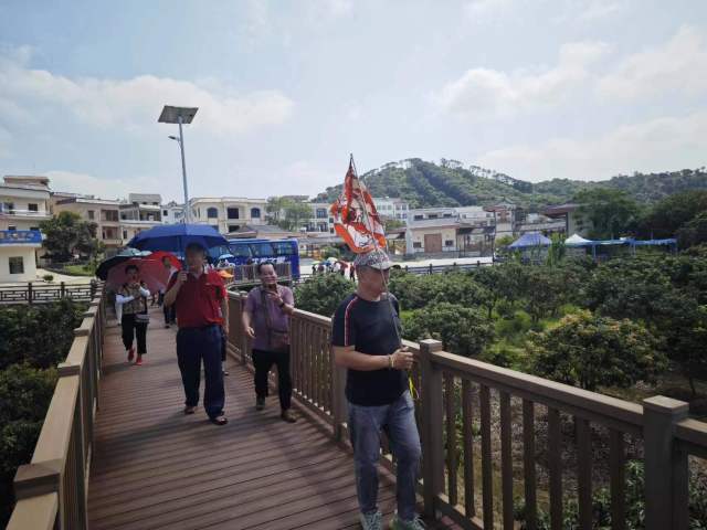 张卓元带的旅游团在古荔园外栈道上参观游玩。