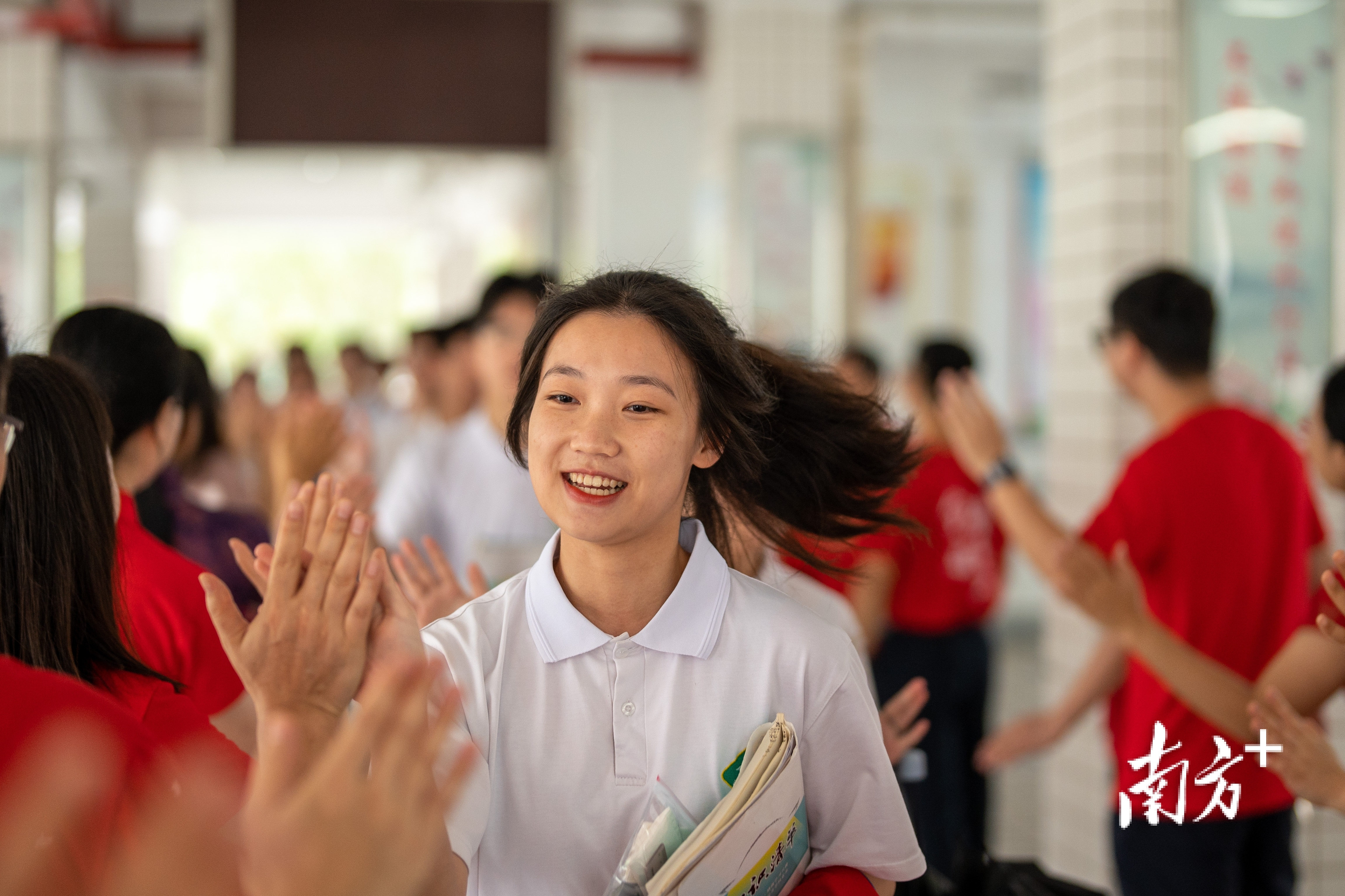 广东肇庆中学的教师高三楼一层排成一队，和考生拍手鼓励送祝福。肇庆发布 廖文奕 摄