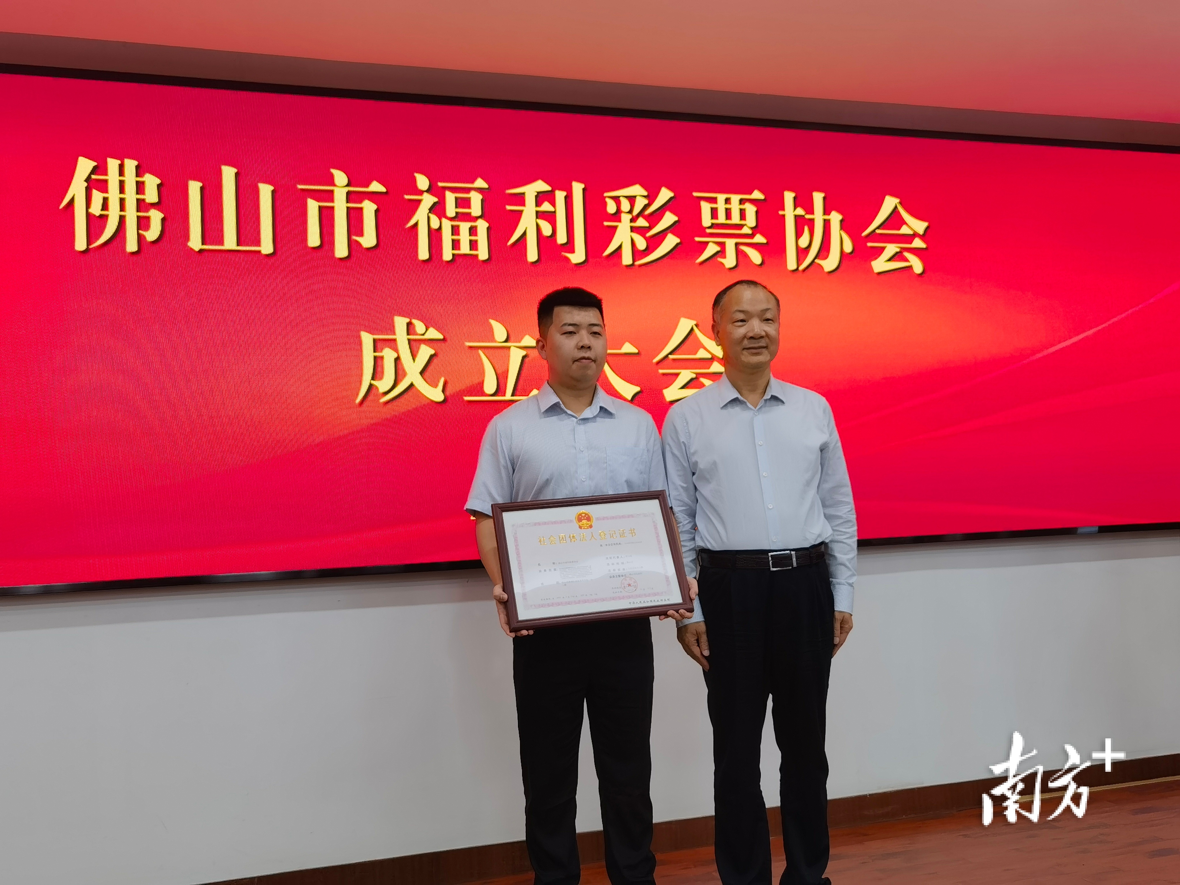 佛山市民政局副局长李木全向佛山市福利彩票协会颁发《社会团体法人登记证书》。   唐梦 摄