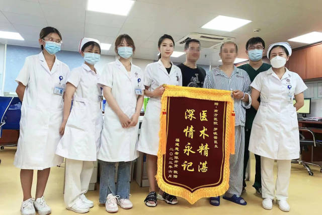 患者为医疗团队送上锦旗致谢。  