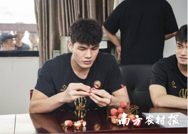 陈国豪等广东工业大学粤狮男篮队品尝从化荔枝。
