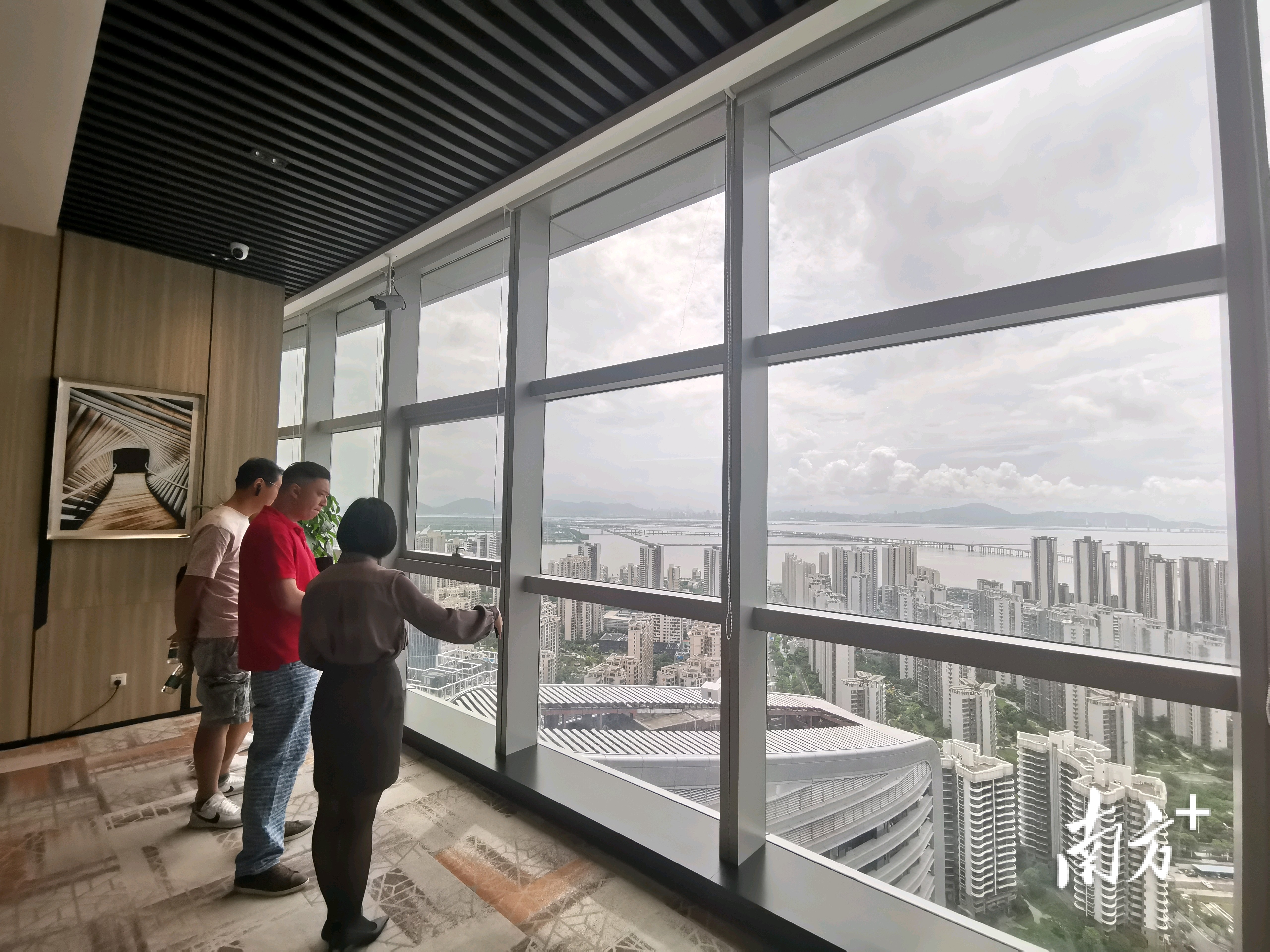 李伯欣和亲友们站在华发商务中心大楼35楼,环视周边景观,复盘自己的港车“西游之路”。 李伯欣和亲友们站在华发商务中心大楼35楼,环视周边景观,复盘自己的港车“西游之路”。