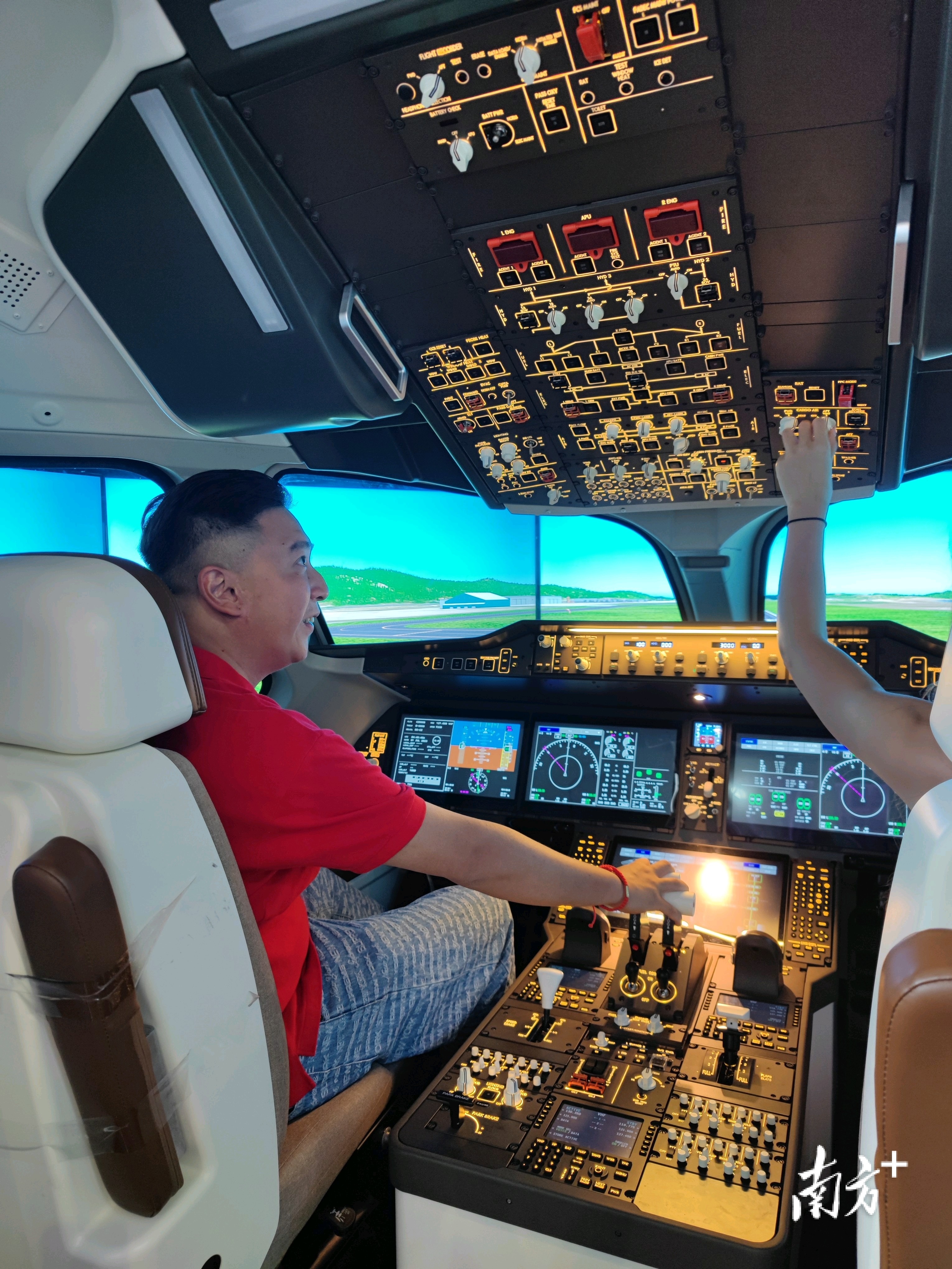 在试驾大飞机c919的互动体验区域,李伯欣登上驾驶舱,操纵模拟器控制