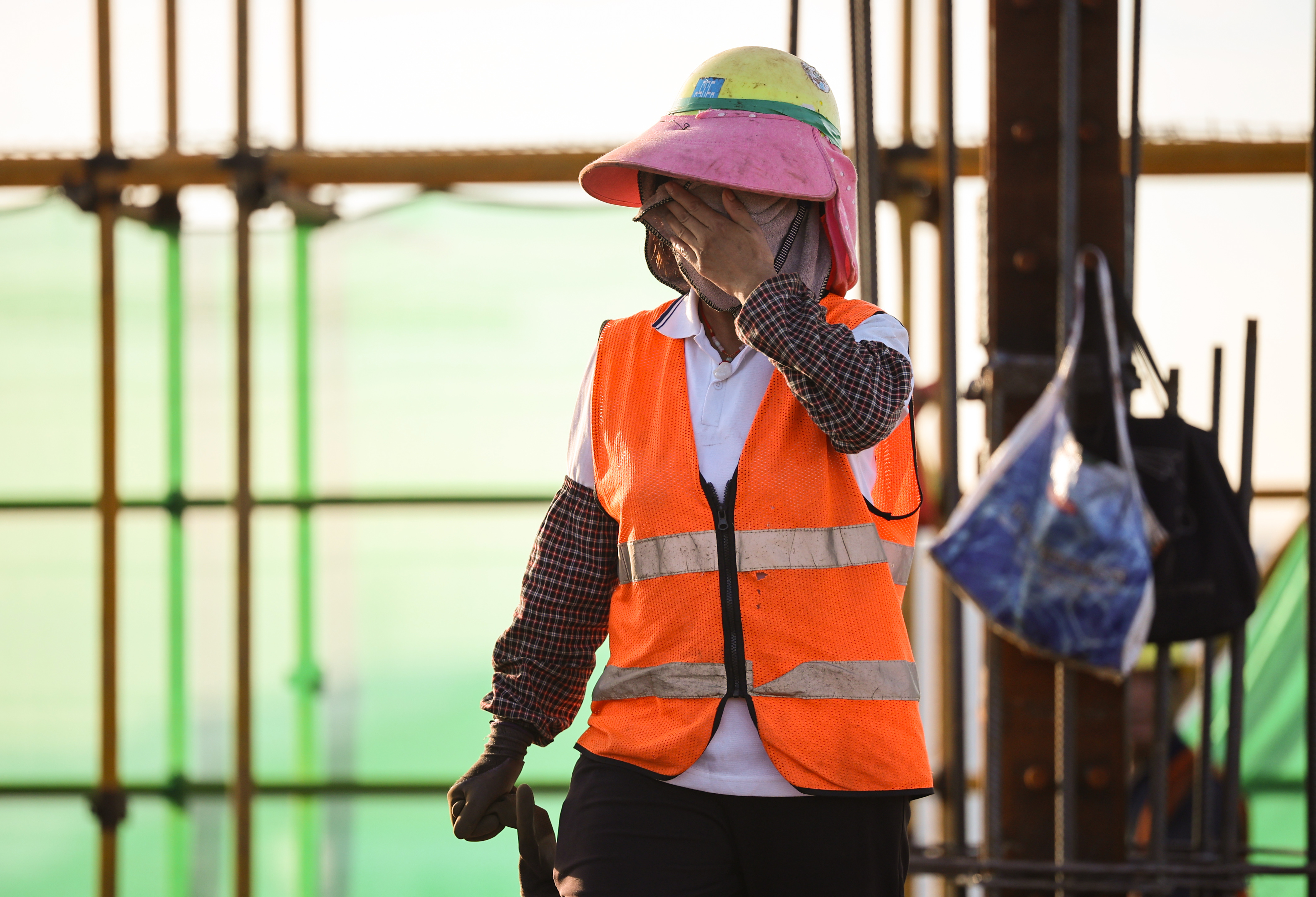 一名工人不时擦拭脸上的汗水。 